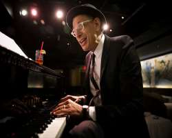 He is a trained piano player and more often performs on Wednesday nights with his band <b>The Mildred Snitzer Orchestra</b> at the Rockwell Club in Lo